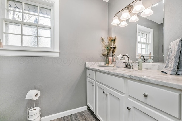 bathroom featuring wood finished floors, vanity, and baseboards