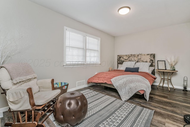 bedroom featuring visible vents, baseboards, and wood finished floors