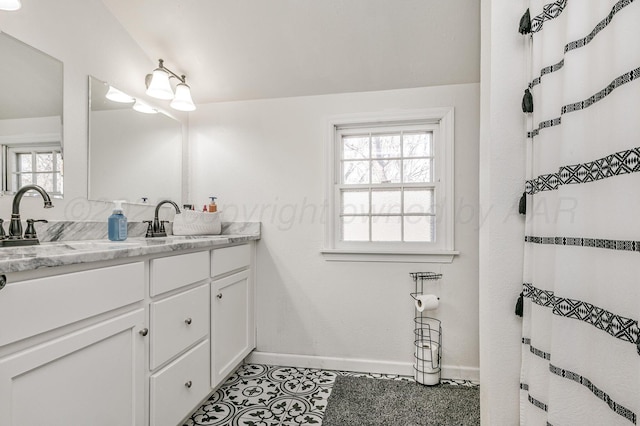 full bath featuring vanity and baseboards