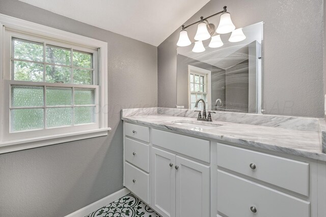 2421 Duncan St, Pampa, TX 79065 - bathroom with vanity, healthy amount of natural light, a textured wall, baseboards, and a chandelier