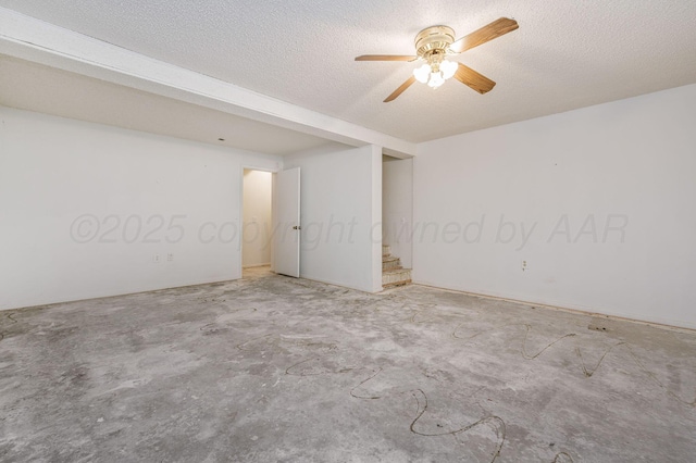 empty room featuring ceiling fan, a textured ceiling, and concrete flooring