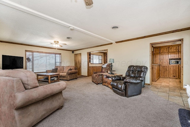 carpeted living room with ceiling fan and crown molding