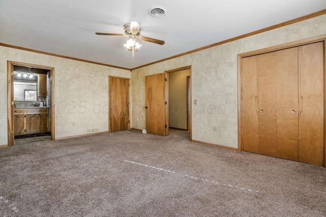 unfurnished bedroom with ceiling fan, crown molding, light colored carpet, and ensuite bath