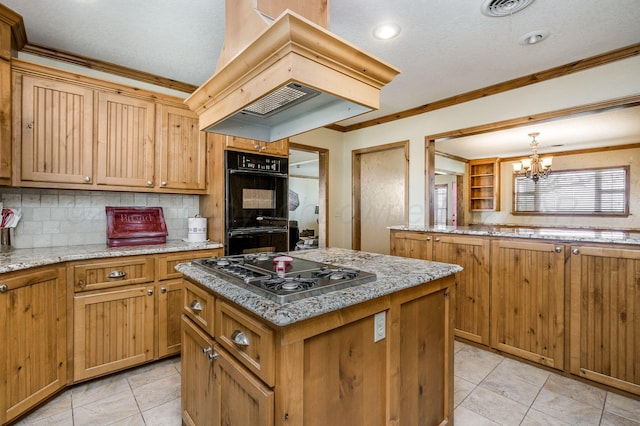 kitchen with stainless steel gas stovetop, a notable chandelier, a center island, custom exhaust hood, and double oven