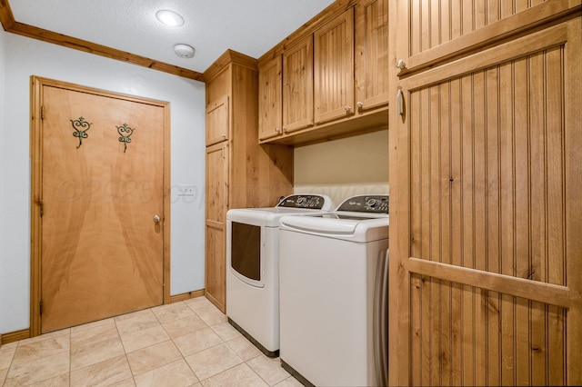 laundry room with cabinets, light tile patterned floors, crown molding, and independent washer and dryer