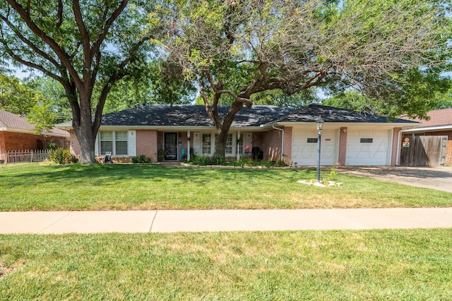 ranch-style home featuring a front lawn, brick siding, fence, and an attached garage