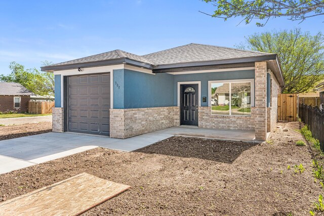307 S Tennessee St, Amarillo, TX 79106 - prairie-style home with driveway, roof with shingles, brick siding, fence, and an attached garage
