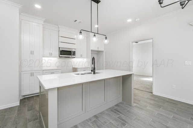 307 S Tennessee St, Amarillo, TX 79106 - kitchen with white cabinets, a sink, light wood-style flooring, stainless steel microwave, and visible vents