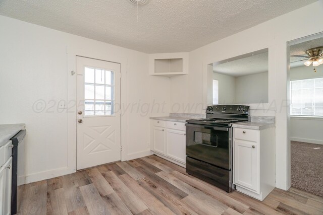 4106 S Jackson St, Amarillo, TX 79110 - kitchen featuring black electric range, light wood finished floors, light countertops, plenty of natural light, and a textured ceiling