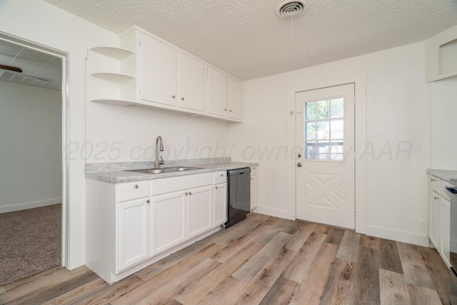 4106 S Jackson St, Amarillo, TX 79110 - kitchen featuring black dishwasher, light countertops, white cabinetry, light wood-type flooring, and a textured ceiling