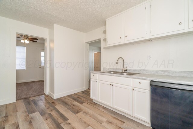 4106 S Jackson St, Amarillo, TX 79110 - kitchen featuring dishwashing machine, light wood-style flooring, light countertops, white cabinetry, and a textured ceiling