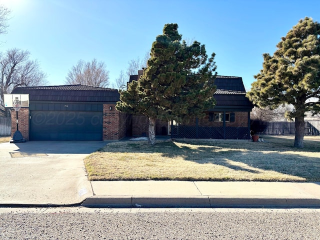 view of front facade with a front lawn, brick siding, driveway, and an attached garage