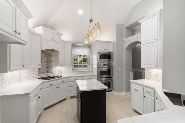 6501 Glenwood Dr, Amarillo, TX 79119 - kitchen featuring stainless steel appliances, vaulted ceiling, arched walkways, and white cabinetry