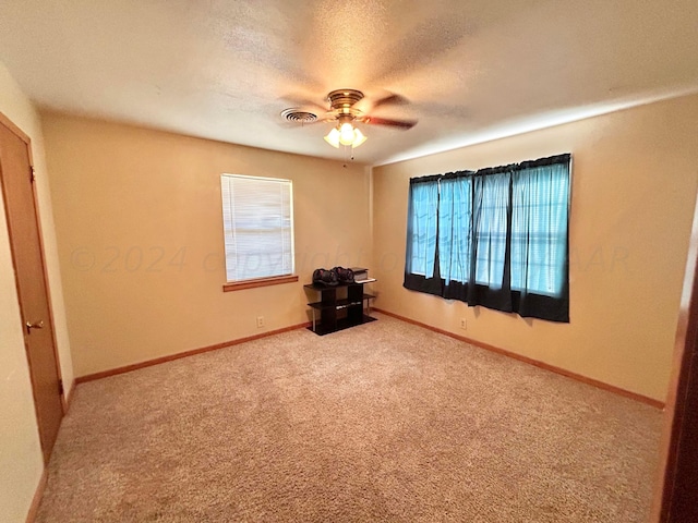 spare room with ceiling fan, carpet, and a textured ceiling