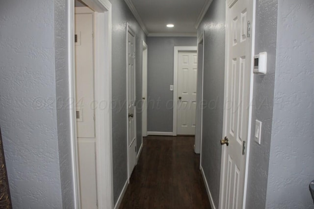 corridor with dark wood finished floors, crown molding, recessed lighting, a textured wall, and baseboards