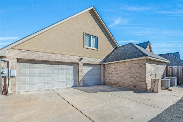 5708 Barrington Ct, Amarillo, TX 79119 - view of side of property featuring central air condition unit, fence, brick siding, a garage, and concrete driveway