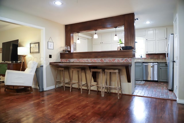 3603 S Lamar St, Amarillo, TX 79109 - kitchen with appliances with stainless steel finishes, dark wood-type flooring, a kitchen bar, white cabinetry, and recessed lighting