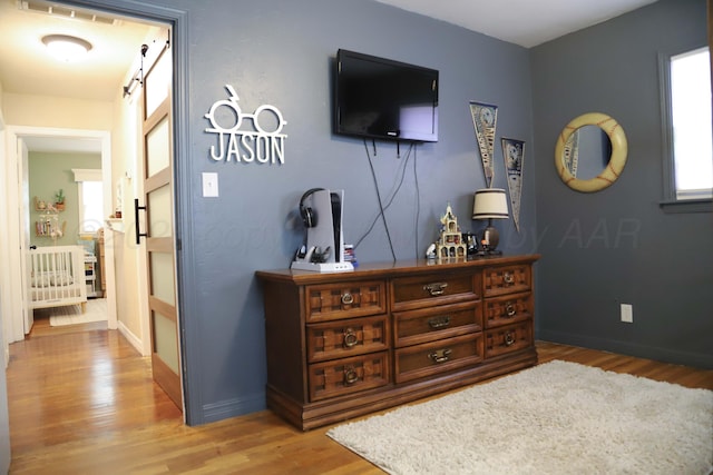 3603 S Lamar St, Amarillo, TX 79109 - bedroom with light wood-style flooring, multiple windows, and a barn door