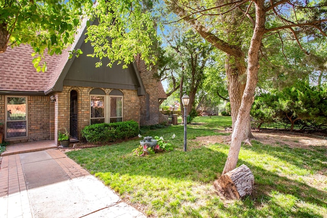 907 Broadmoor St, Amarillo, TX 79106 - view of front facade with roof with shingles, a front lawn, and brick siding
