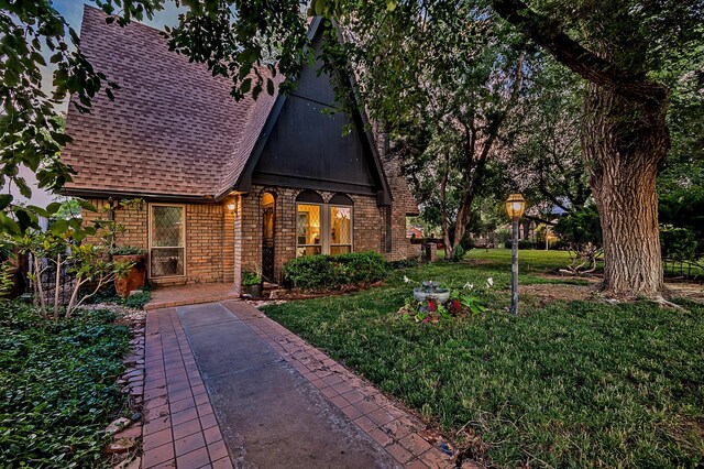 907 Broadmoor St, Amarillo, TX 79106 - tudor house featuring a shingled roof, brick siding, and a front yard