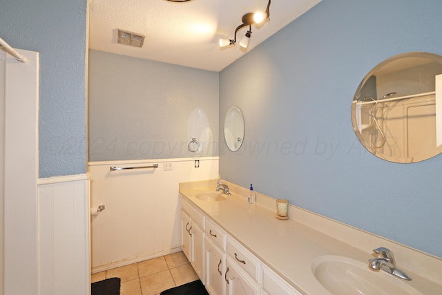 bathroom with tile patterned floors, vanity, and a textured ceiling