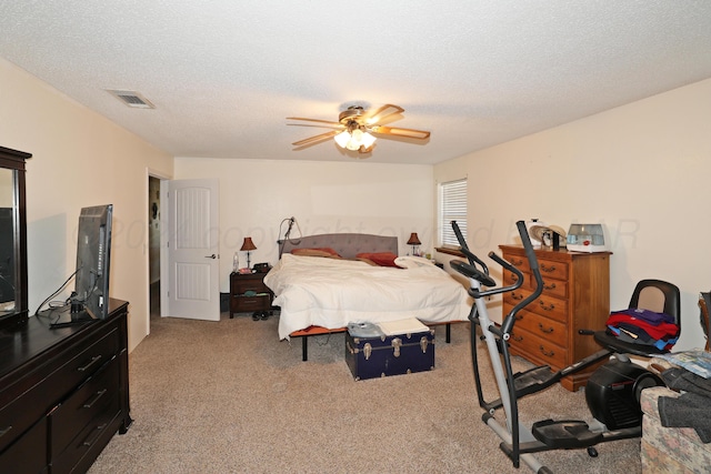 carpeted bedroom featuring a textured ceiling and ceiling fan