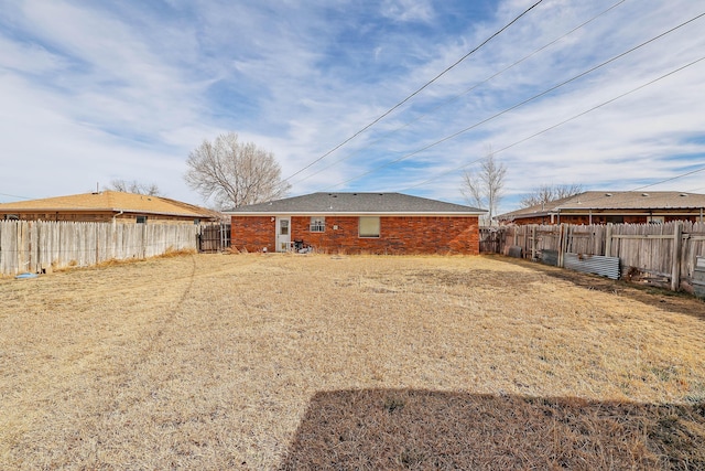 rear view of house featuring a fenced backyard