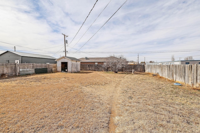 view of yard featuring an outbuilding, a storage unit, and a fenced backyard