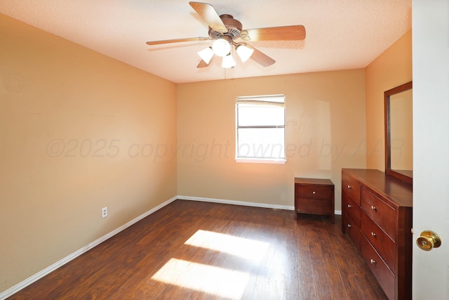 unfurnished bedroom featuring dark wood finished floors, baseboards, and a ceiling fan