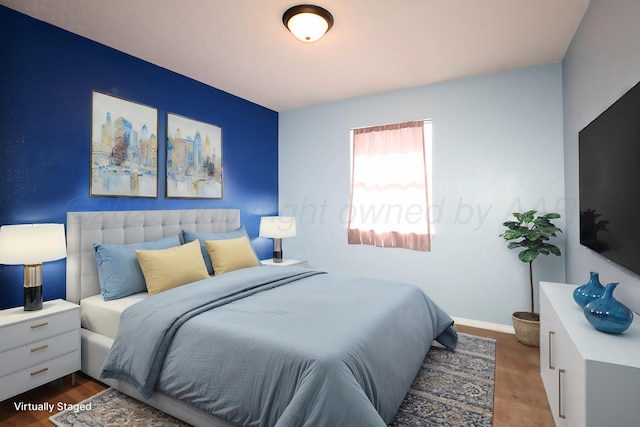bedroom with baseboards and wood finished floors