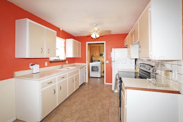 kitchen with electric stove, light countertops, washer / dryer, and a sink