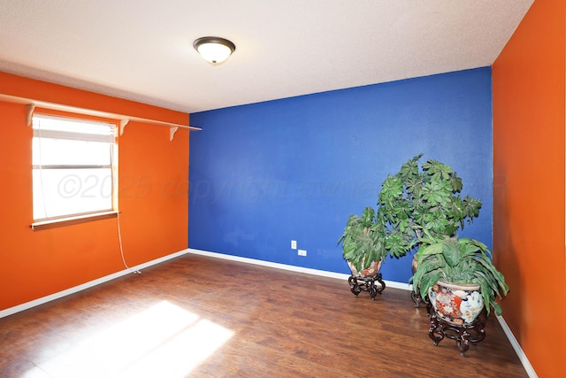 empty room featuring baseboards and wood finished floors