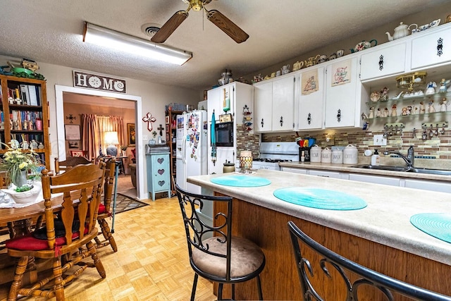 1010 E 3rd St, Clarendon, TX 79226 - kitchen featuring white appliances, a sink, light countertops, a ceiling fan, and white cabinetry