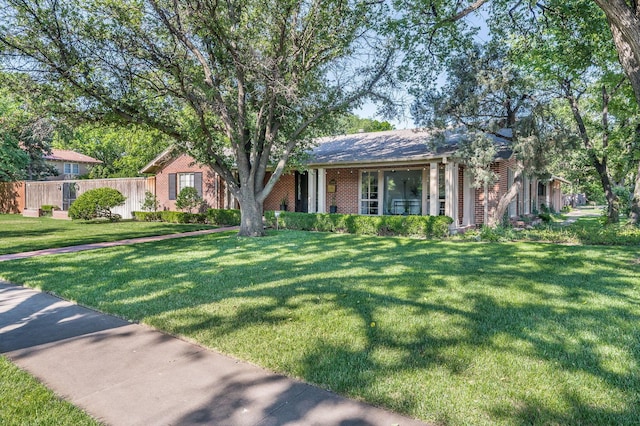 view of front of property featuring fence, a front lawn, and brick siding