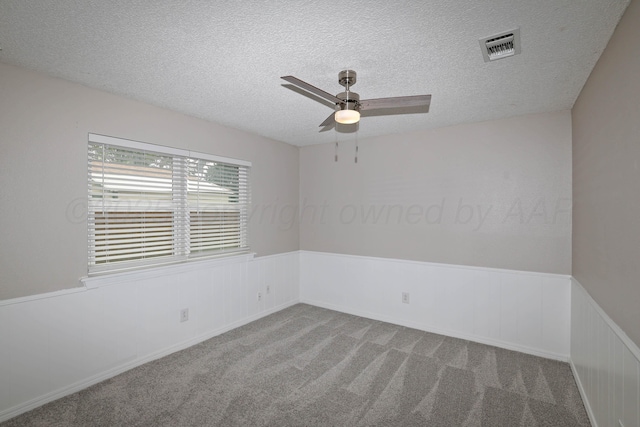 7426 Jameson Dr, Amarillo, TX 79121 - carpeted spare room with a wainscoted wall, a textured ceiling, and a ceiling fan