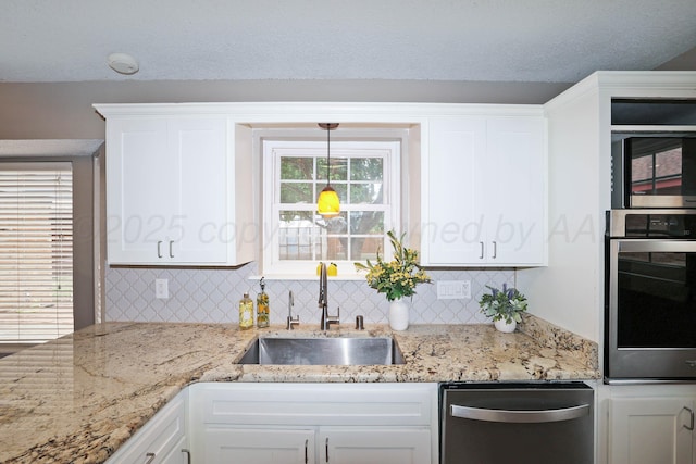 7426 Jameson Dr, Amarillo, TX 79121 - kitchen featuring stainless steel appliances, white cabinetry, decorative backsplash, and light stone counters