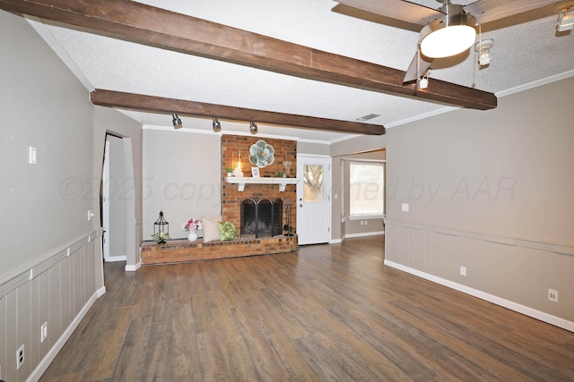 7426 Jameson Dr, Amarillo, TX 79121 - unfurnished living room featuring beamed ceiling, wood finished floors, a brick fireplace, wainscoting, and a decorative wall