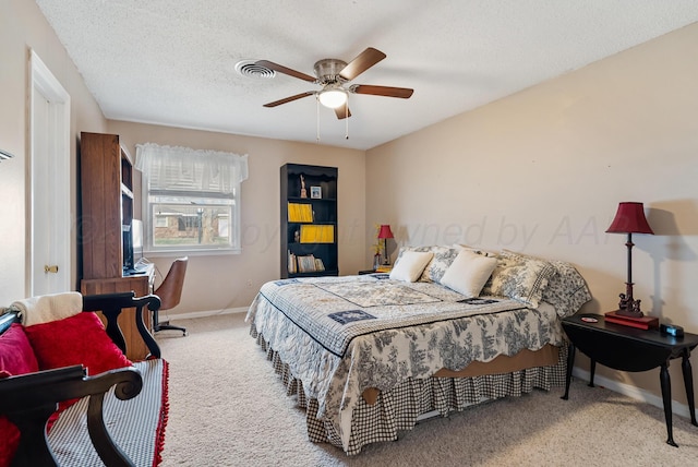 carpeted bedroom featuring baseboards, a textured ceiling, ceiling fan, and visible vents