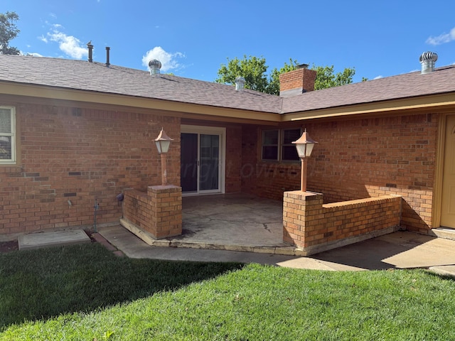 409 Thompson Ln, Canyon, TX 79015 - rear view of property featuring brick siding, a patio, a chimney, and a yard
