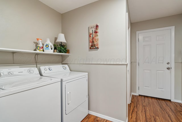 clothes washing area featuring independent washer and dryer, laundry area, baseboards, and wood finished floors