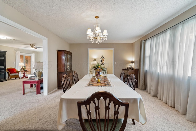 dining room with a chandelier, a textured ceiling, and light colored carpet