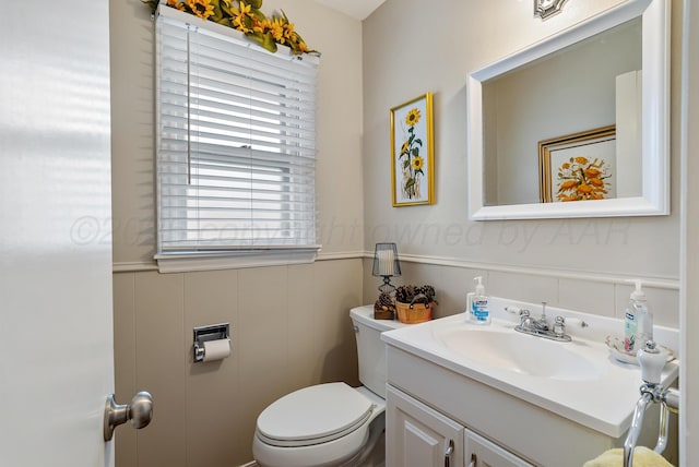 bathroom featuring a wainscoted wall, vanity, and toilet