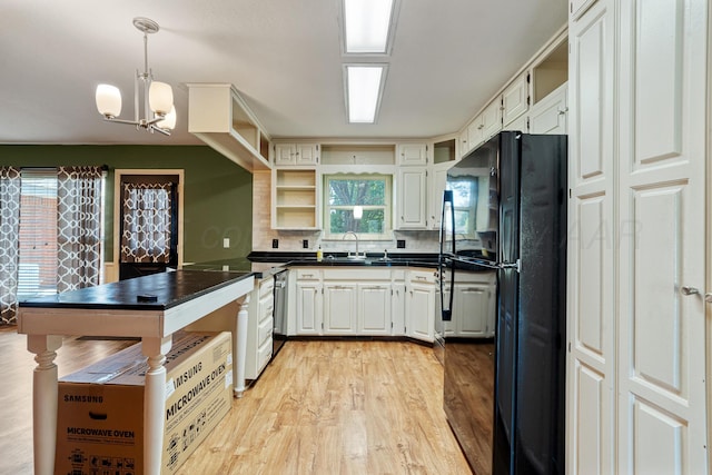 1604 Country Ln, Panhandle, TX 79068 - kitchen with freestanding refrigerator, dark countertops, open shelves, light wood-style flooring, and a peninsula