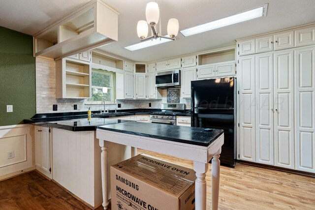 1604 Country Ln, Panhandle, TX 79068 - kitchen featuring stainless steel appliances, open shelves, dark countertops, a peninsula, and decorative backsplash