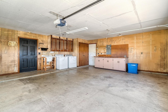 1604 Country Ln, Panhandle, TX 79068 - garage featuring washing machine and clothes dryer, a garage door opener, electric panel, and wooden walls