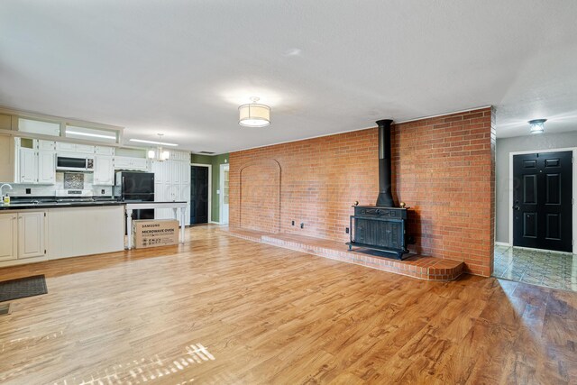 1604 Country Ln, Panhandle, TX 79068 - unfurnished living room featuring light wood-style flooring and a wood stove