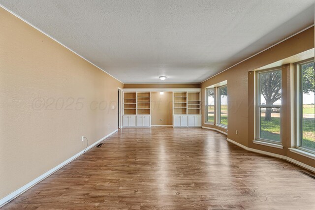 1604 Country Ln, Panhandle, TX 79068 - unfurnished room featuring wood finished floors, a textured ceiling, and plenty of natural light