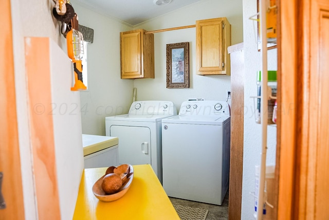 clothes washing area featuring cabinets, crown molding, and independent washer and dryer