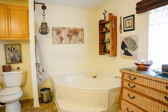 bathroom with tile patterned flooring, vanity, toilet, crown molding, and a bath