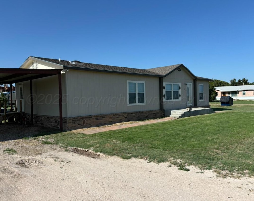 103 E 4th St, Wildorado, TX 79098 - view of side of property featuring a lawn, driveway, and a carport